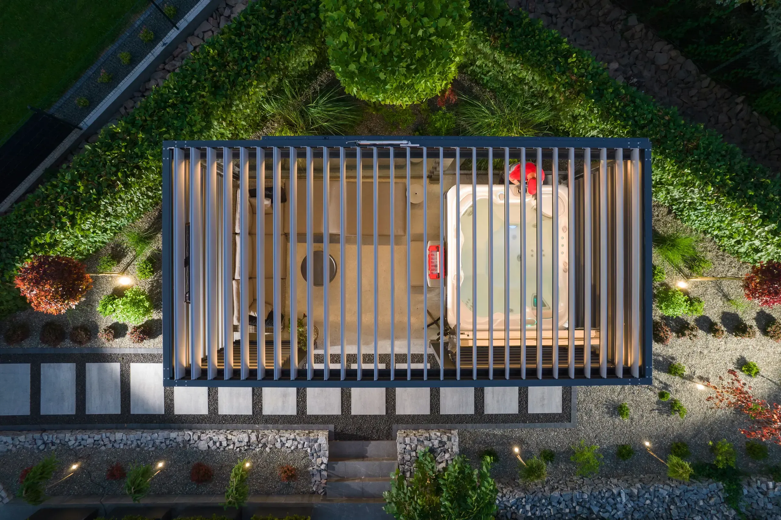 Pergola metalowa z lamelowym zadaszeniem, jacuzzi i miejscem wypoczynkowym w ogrodzie