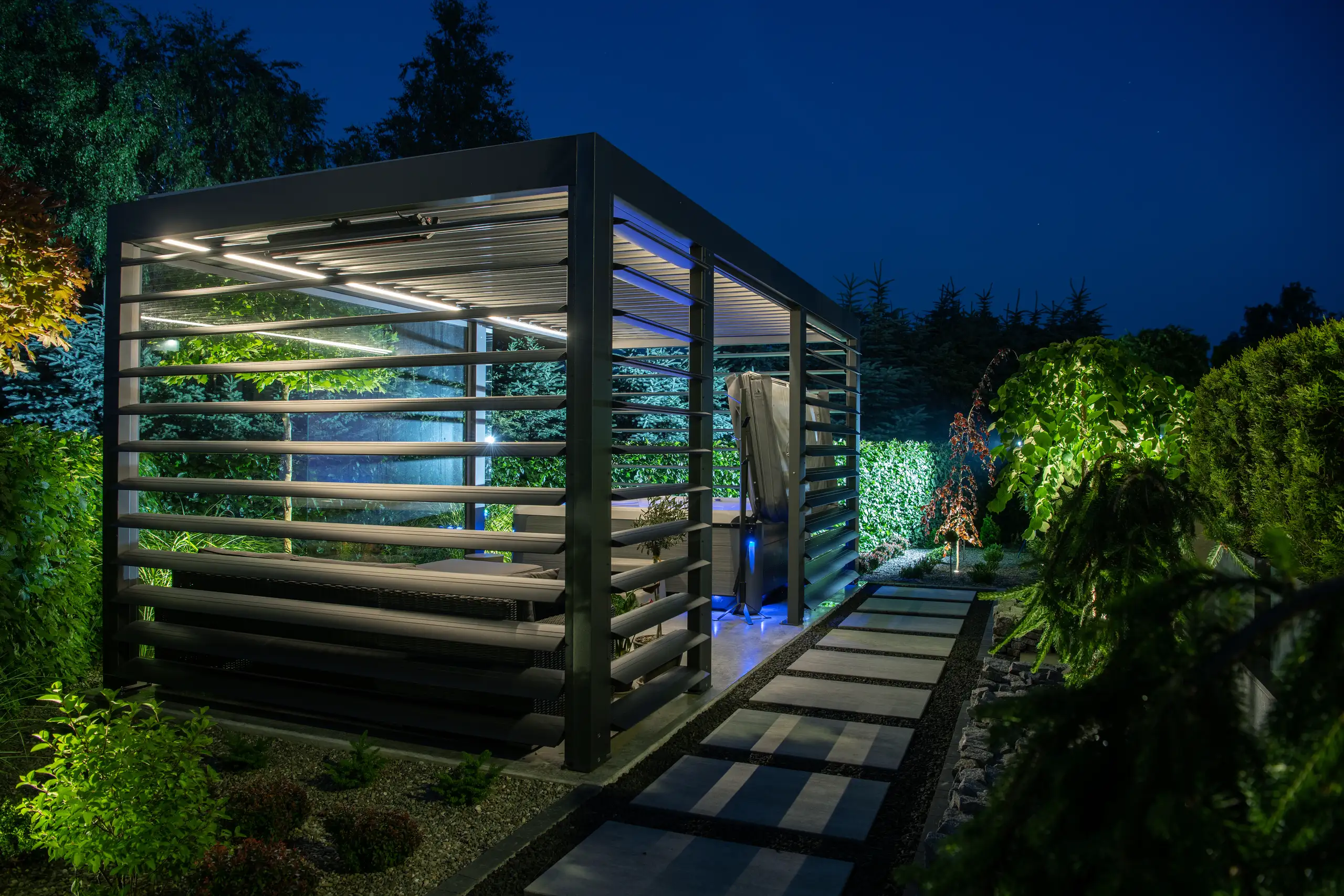 Pergola metalowa z lamelami i oświetleniem w ogrodzie nocą